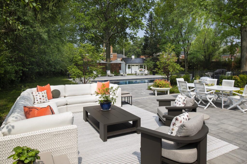Outdoor area with comfortable couches, dining table, and a view of the swimming pool