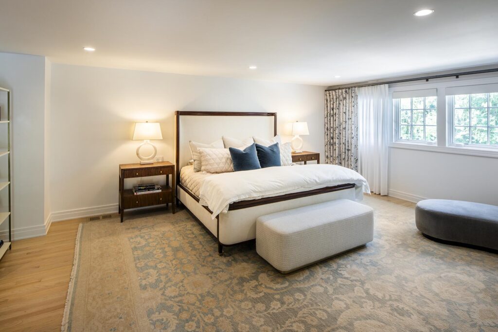 Spacious bedroom featuring a neatly made bed with modern decor