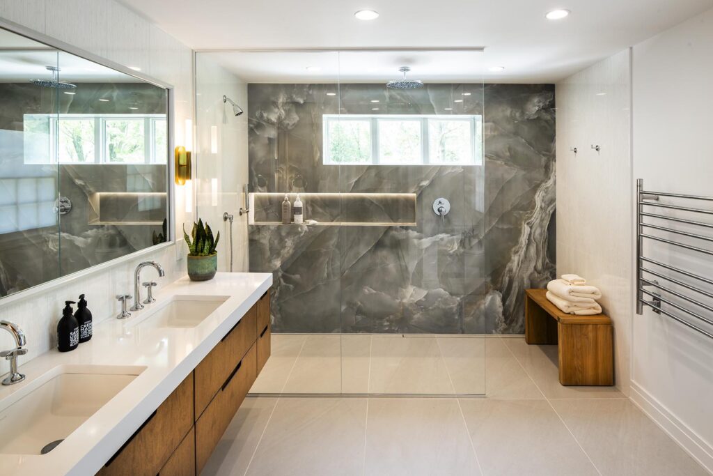 Modern bathroom with double sinks, mirror, and glass shower