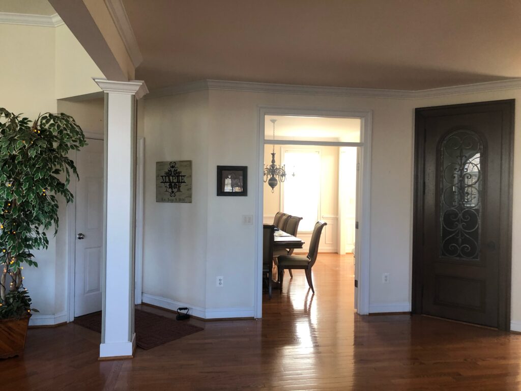Before remodel – narrow, dark, and uninspired foyer in a Purcellville home with limited natural light and dated finishes.