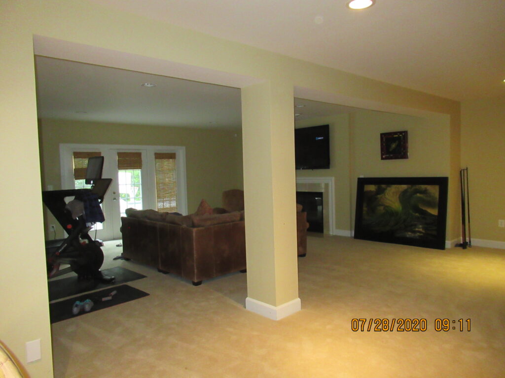 Before remodel – uninspired builder-grade basement in a Leesburg home, with plain walls and minimal design that did not meet the needs of a family who loved to entertain.