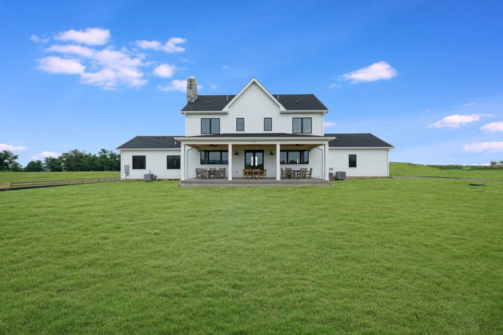 Digital rendering of a modern white farmhouse with covered back porch and outdoor living space designed by Alair Homes Hunt Country.