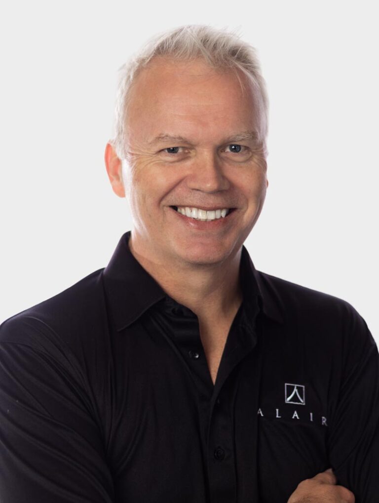 Rob Cecil, CEO of Alair Homes. Wearing an Alair Homes shirt against pewter background.