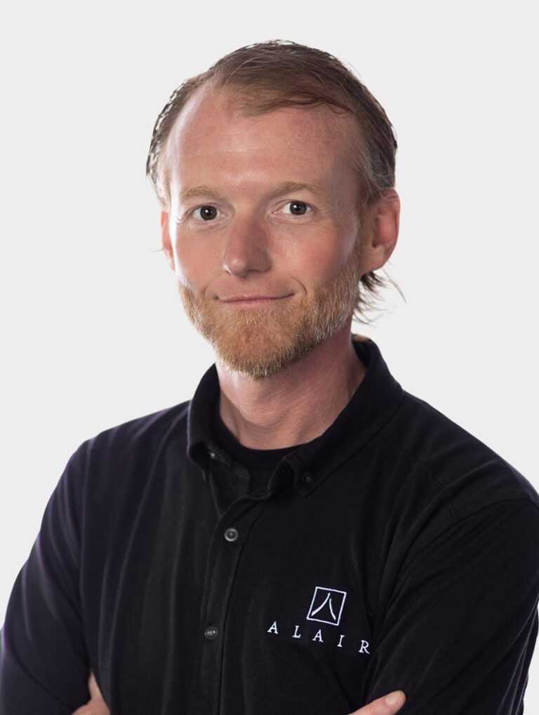 Shane Duff, Director of Partner Services at Alair Homes, Wearing an Alair Homes shirt against pewter background.