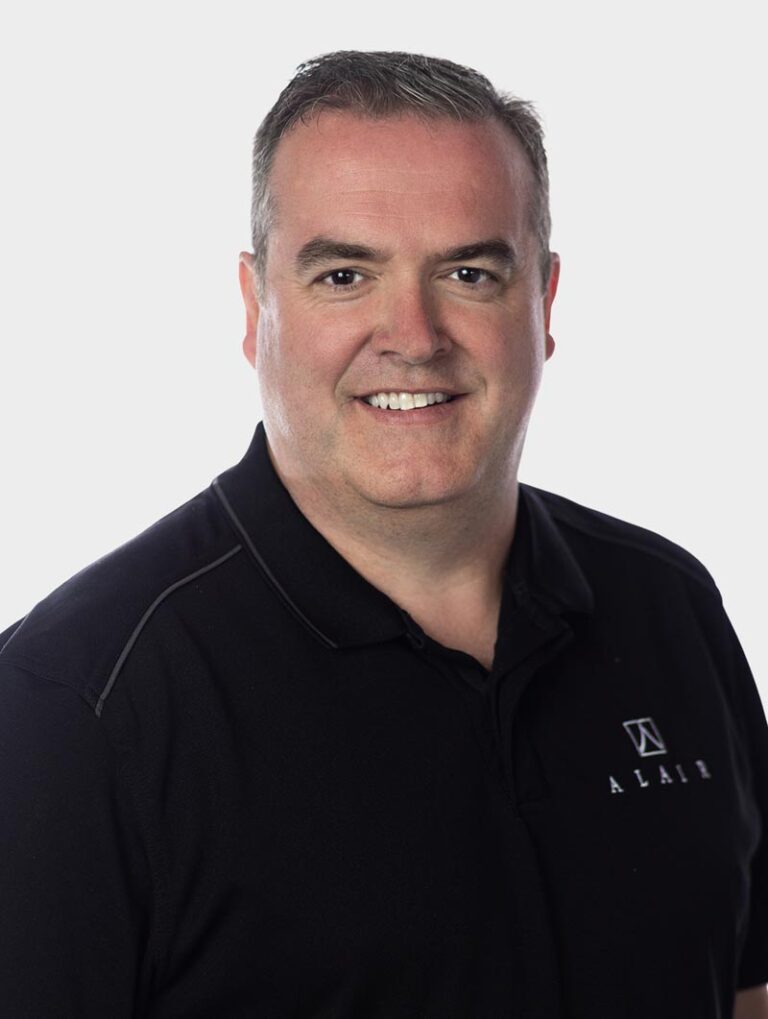 Stu Hopewell, Chief Compliance Officer at Alair Homes, Wearing an Alair Homes shirt against pewter background.
