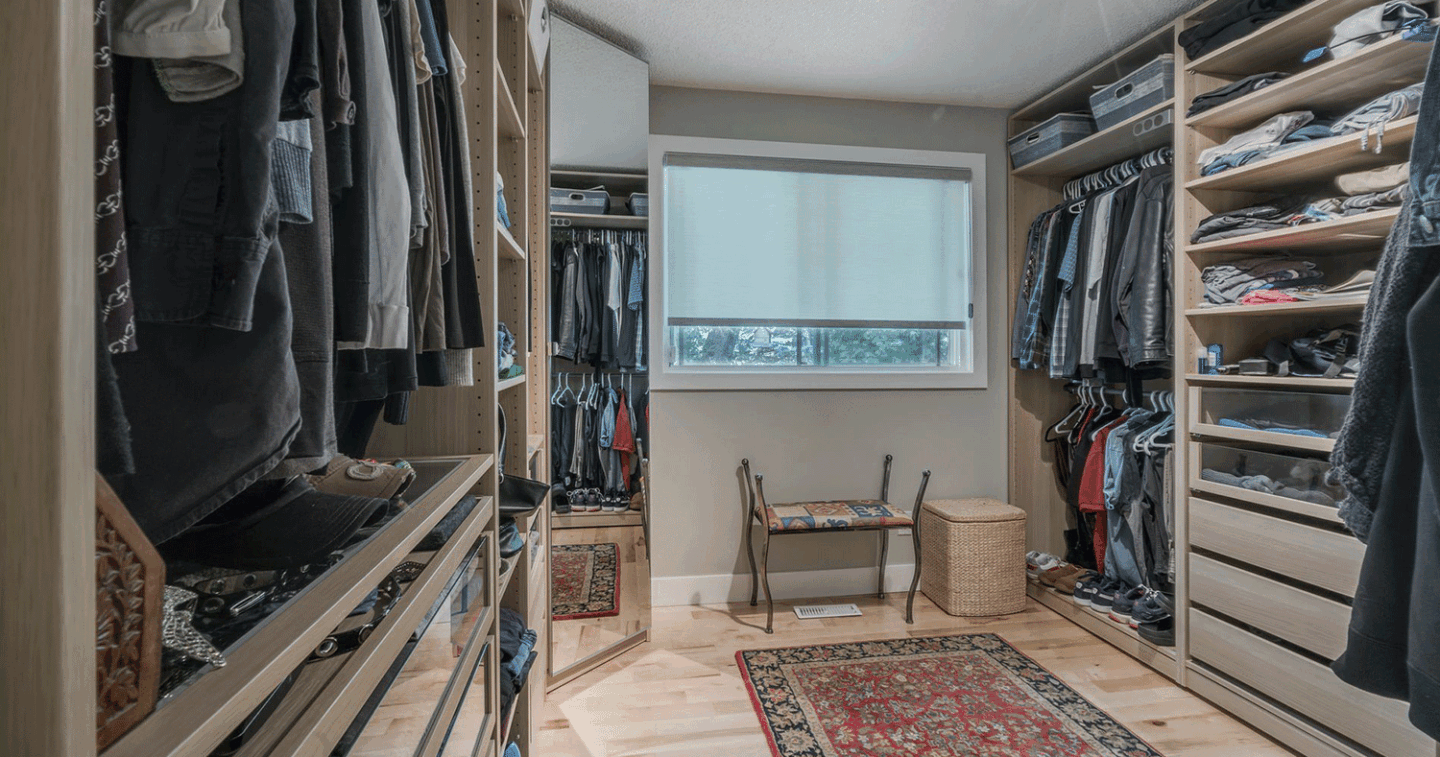 walk in closet with built in shelves multiple hanging rods and a window seat
