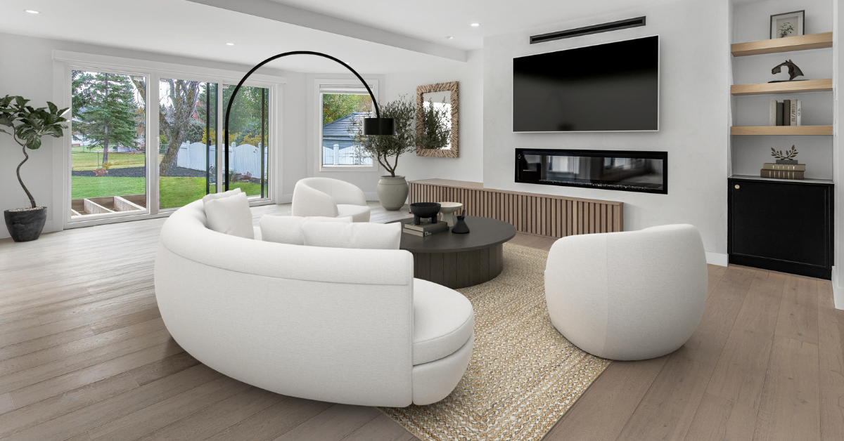 Image is of a modern living room, with a large white curged couch facing a flatscreen tv.