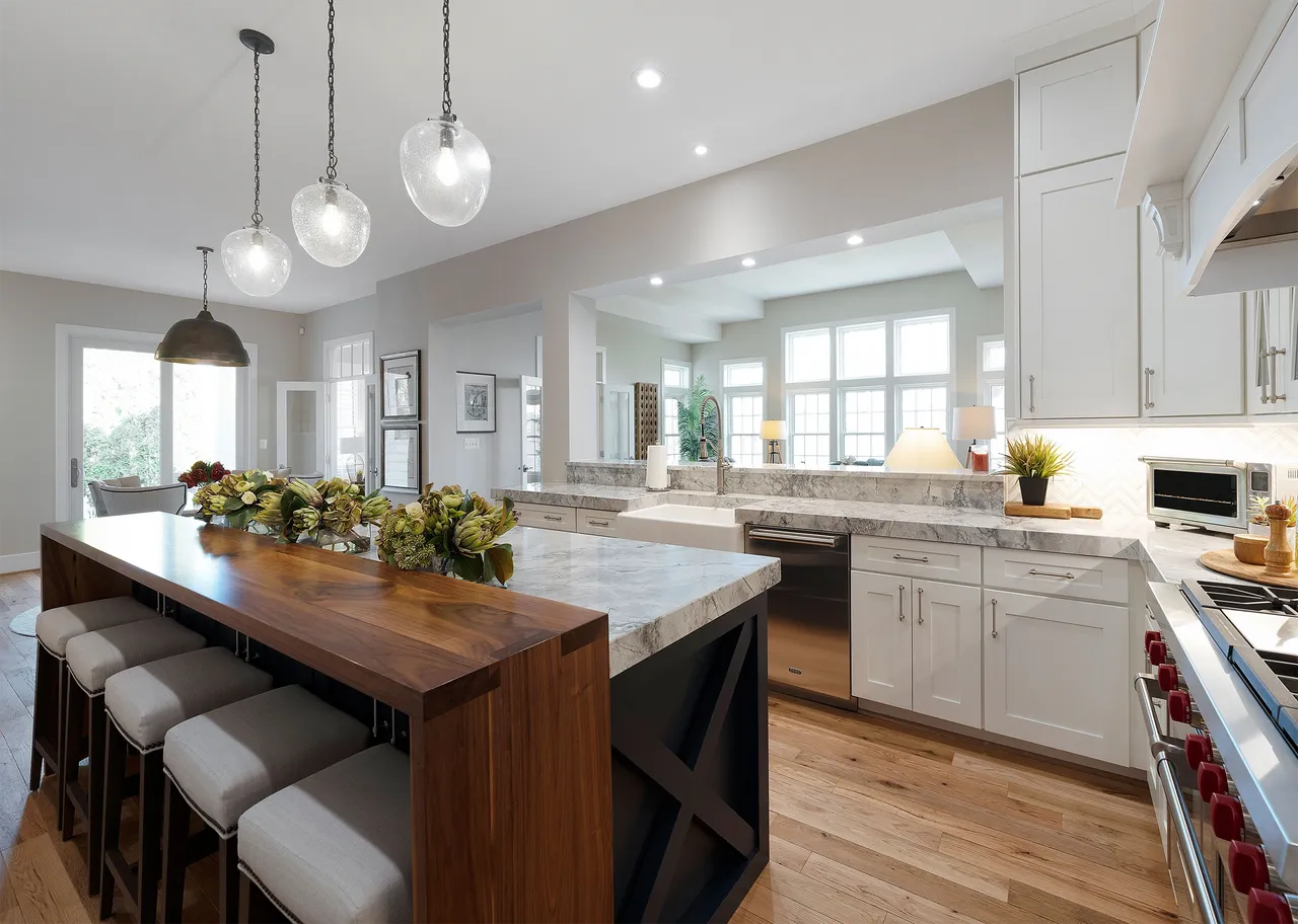 classic white cabinetry and polished countertops contrasted by a bold island wrapped in reclaimed wood