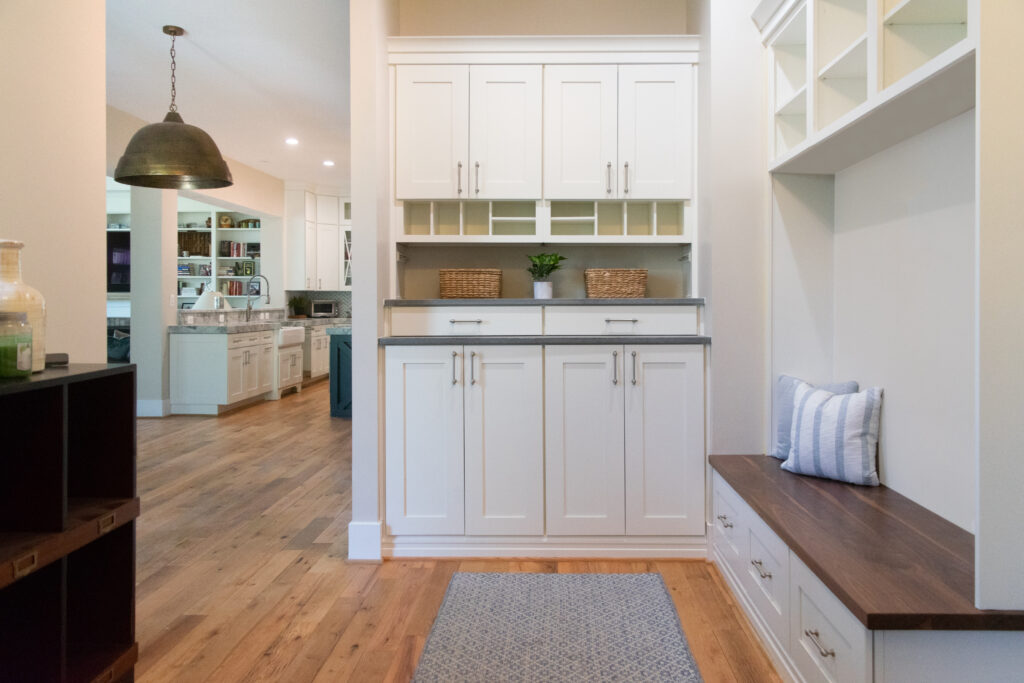 L-shaped family foyer with closed cabinets, built-in bench, and custom storage for an organized entryway in Leesburg, Virginia renovation