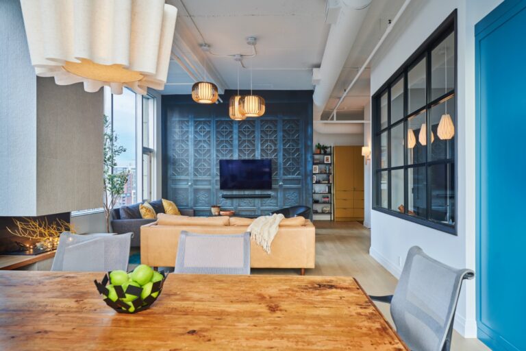 Open concept condo with accent wall, dining area and cozy fireplace.