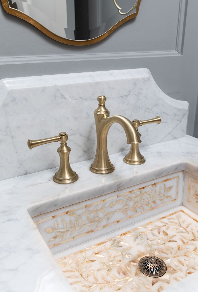 Elegant brushed gold bathroom faucet fixture on marble countertop in a custom home by Alair Homes Hunt Country