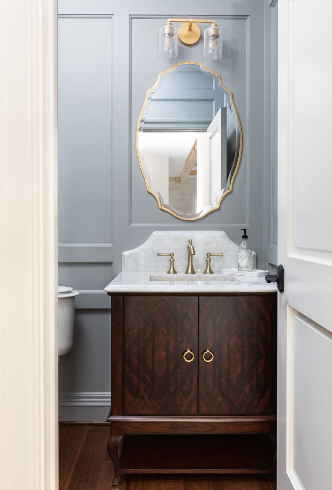 Well-appointed entry bathroom with stylish finishes, custom vanity, and modern lighting