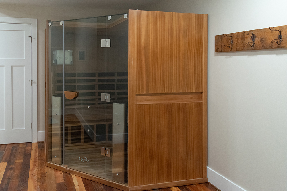 Luxury home wellness retreat featuring a custom glass and wood sauna in a Loudoun County renovation by Alair Homes Hunt Country.