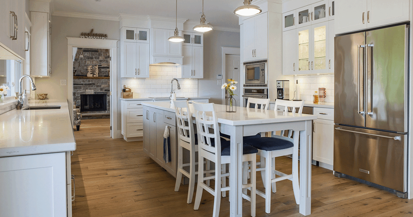 custom all white kitchen with four seat table connected to island