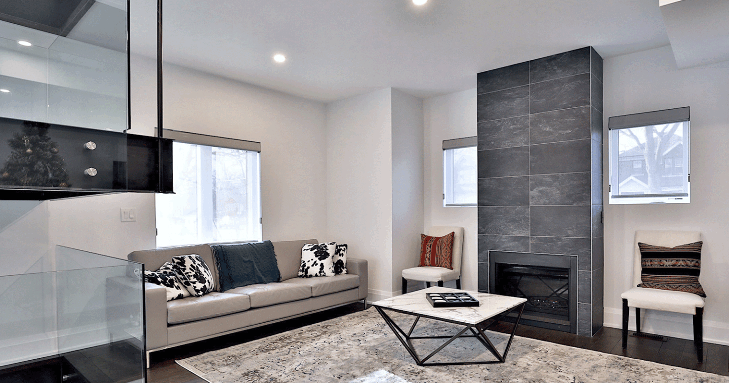 modern custom living space with glass room divider and stone fireplace