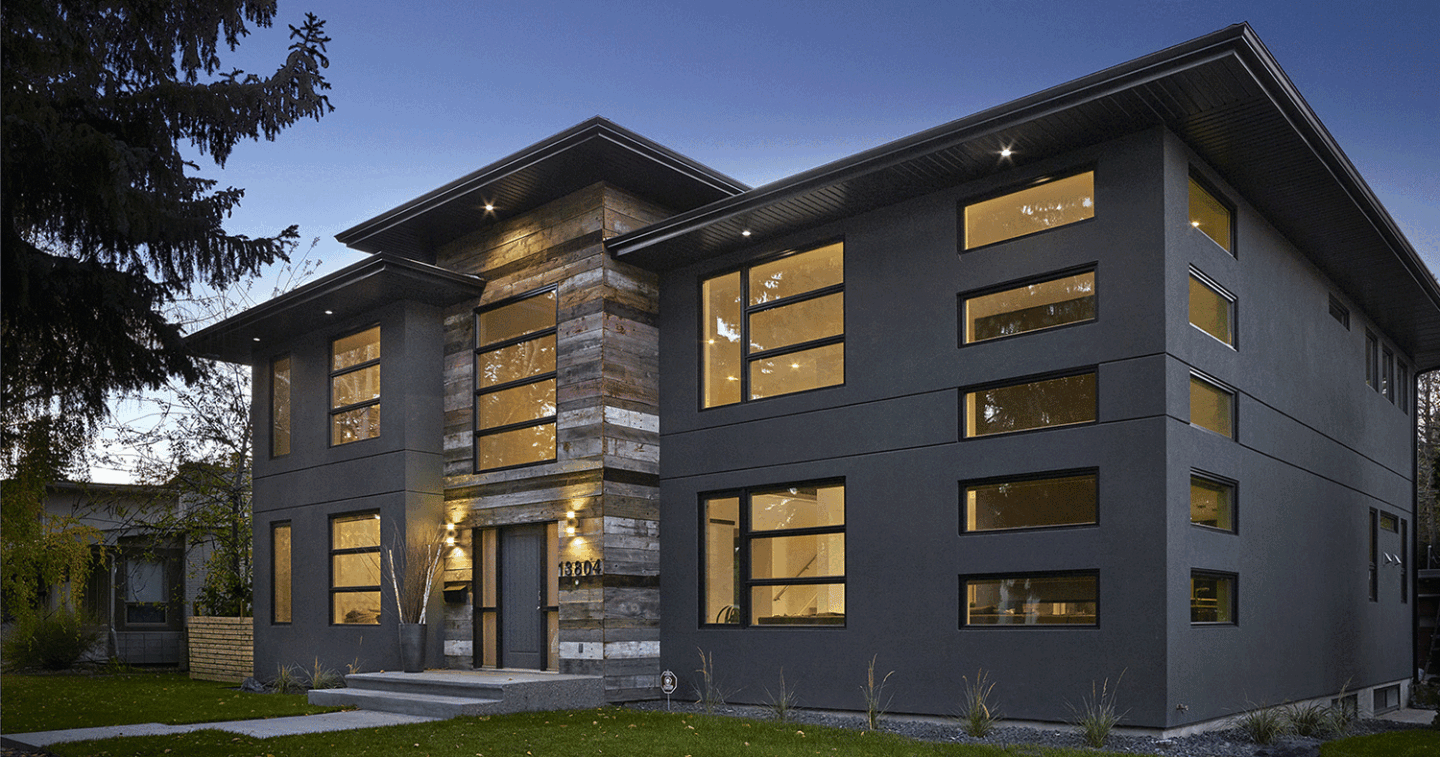 Exterior of large multi-story custom home at dusk with many flat rectangular windows