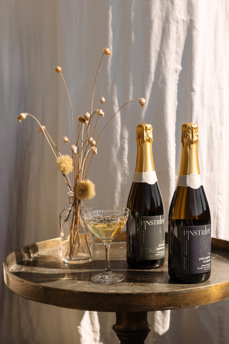 a photo of 2 bottles of sparkling wine exclusively made by Pinstripe Wines | Amy Andrews