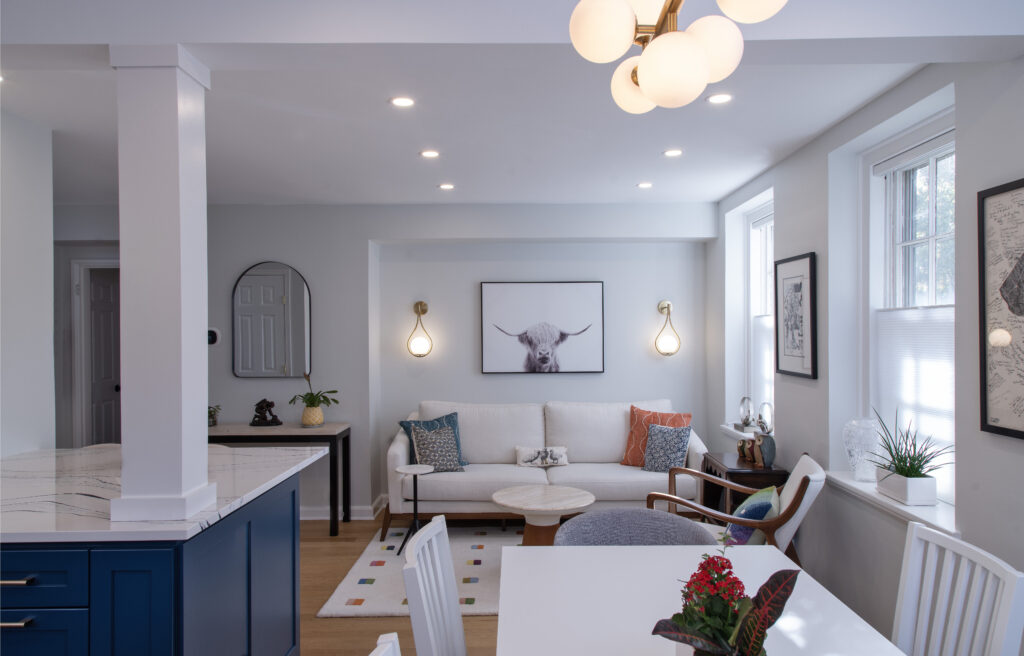 View from the dining table into an open living room with a white couch.