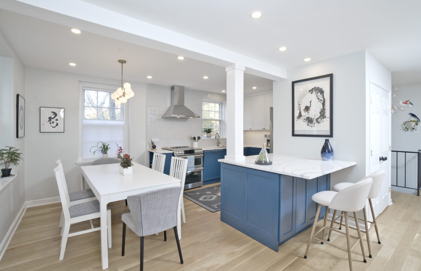Bright and open kitchen and dining space with blue cabinetry