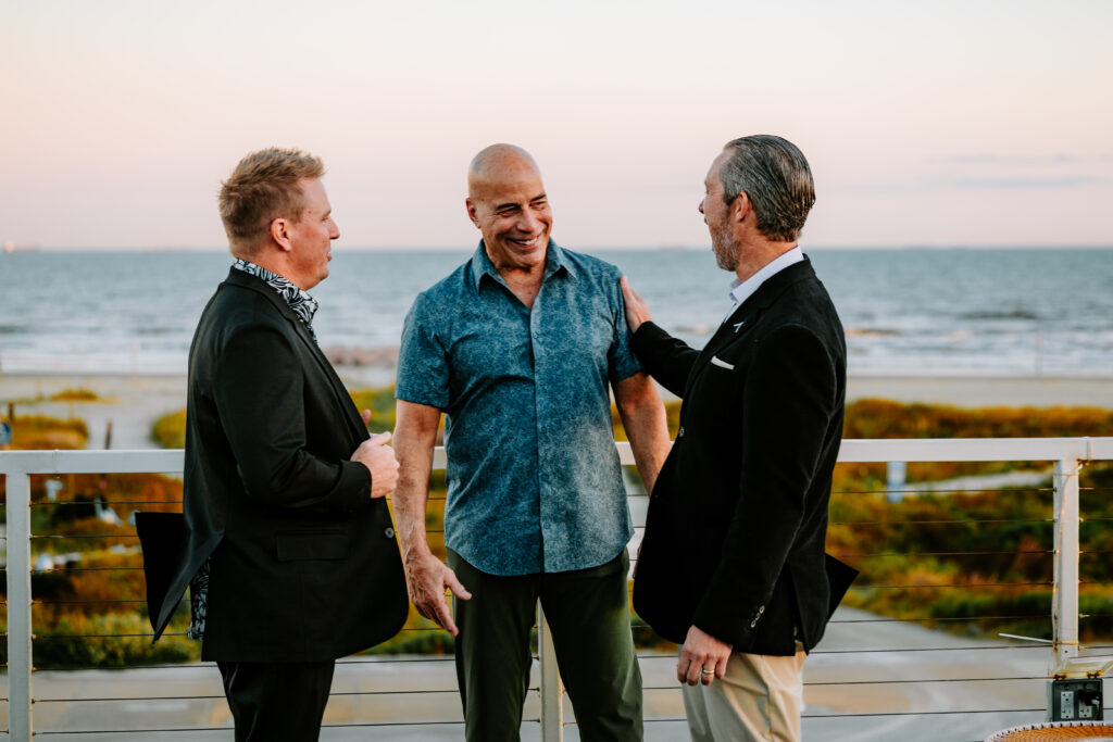 Bryan Phillips, Manny Mehos, and Hugh Forque laughing together at the coastal launch party