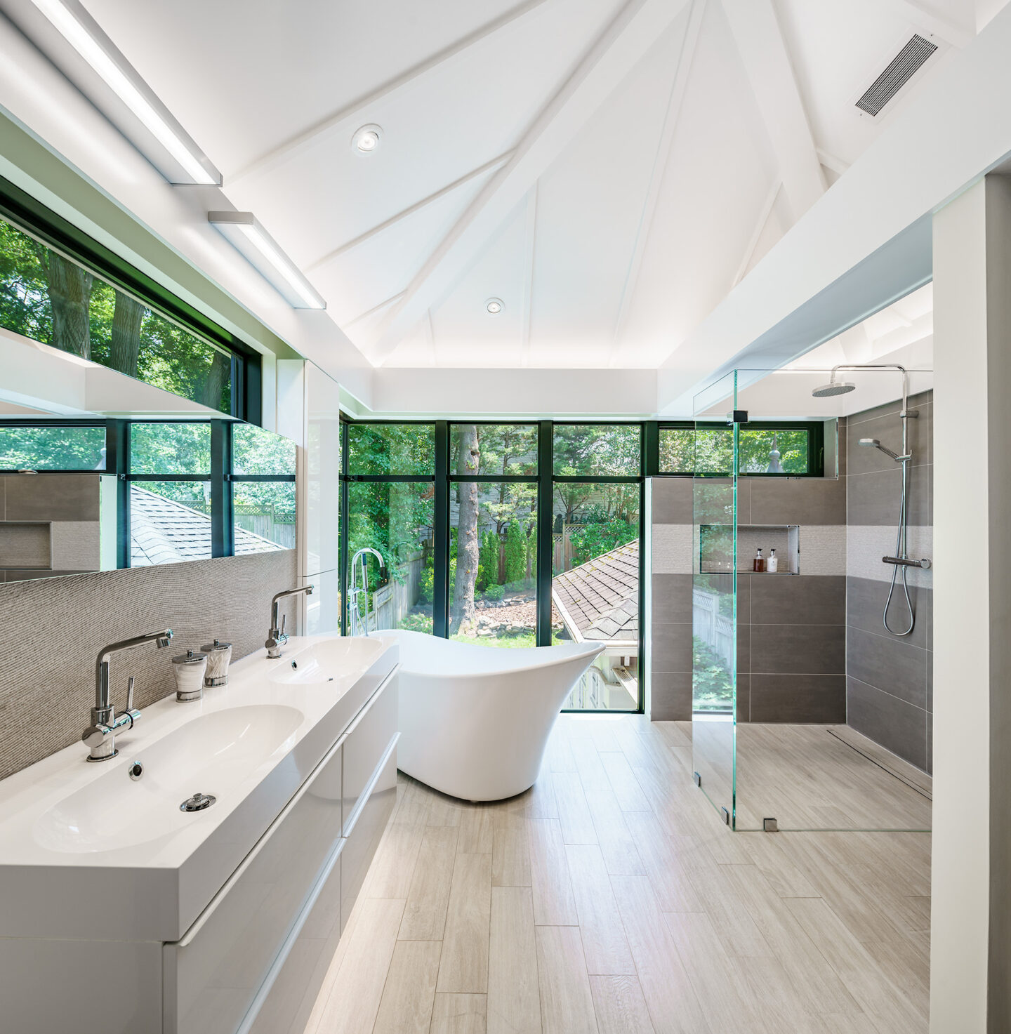 Light-filled bathroom with a curbless shower and a freestanding tub.