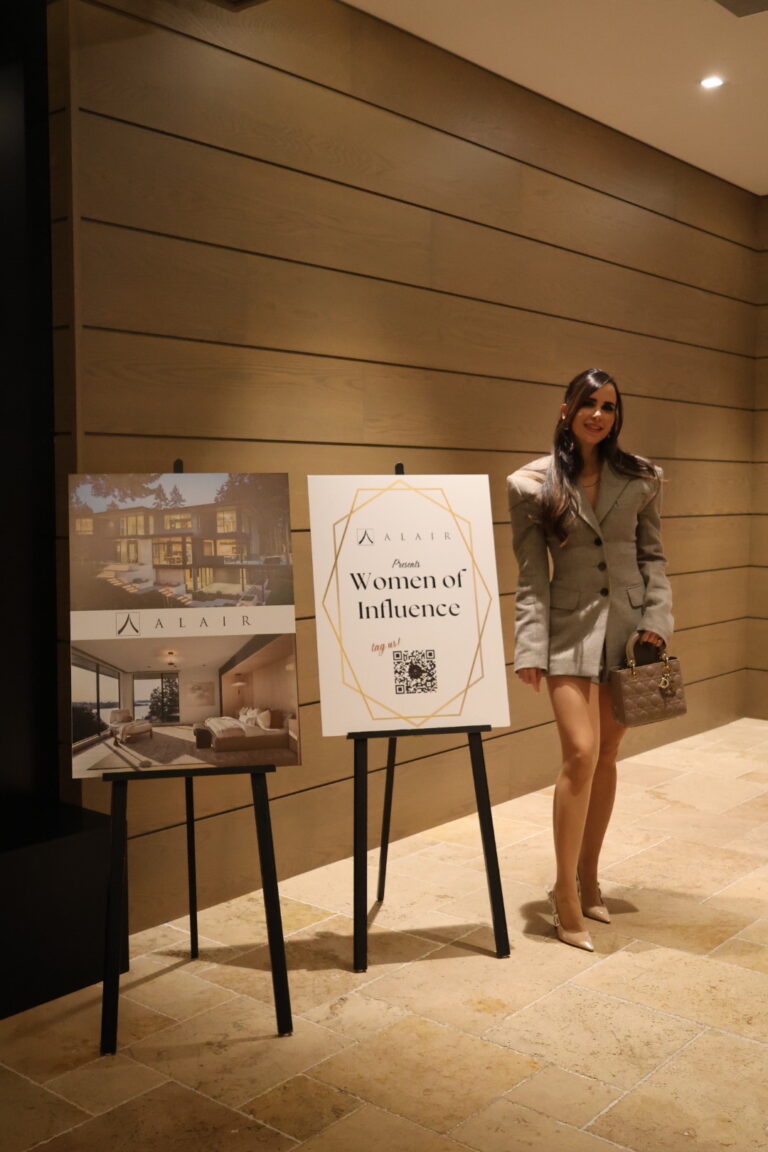 one of the attendees of Women of Influence Event is posing in front of a sign
