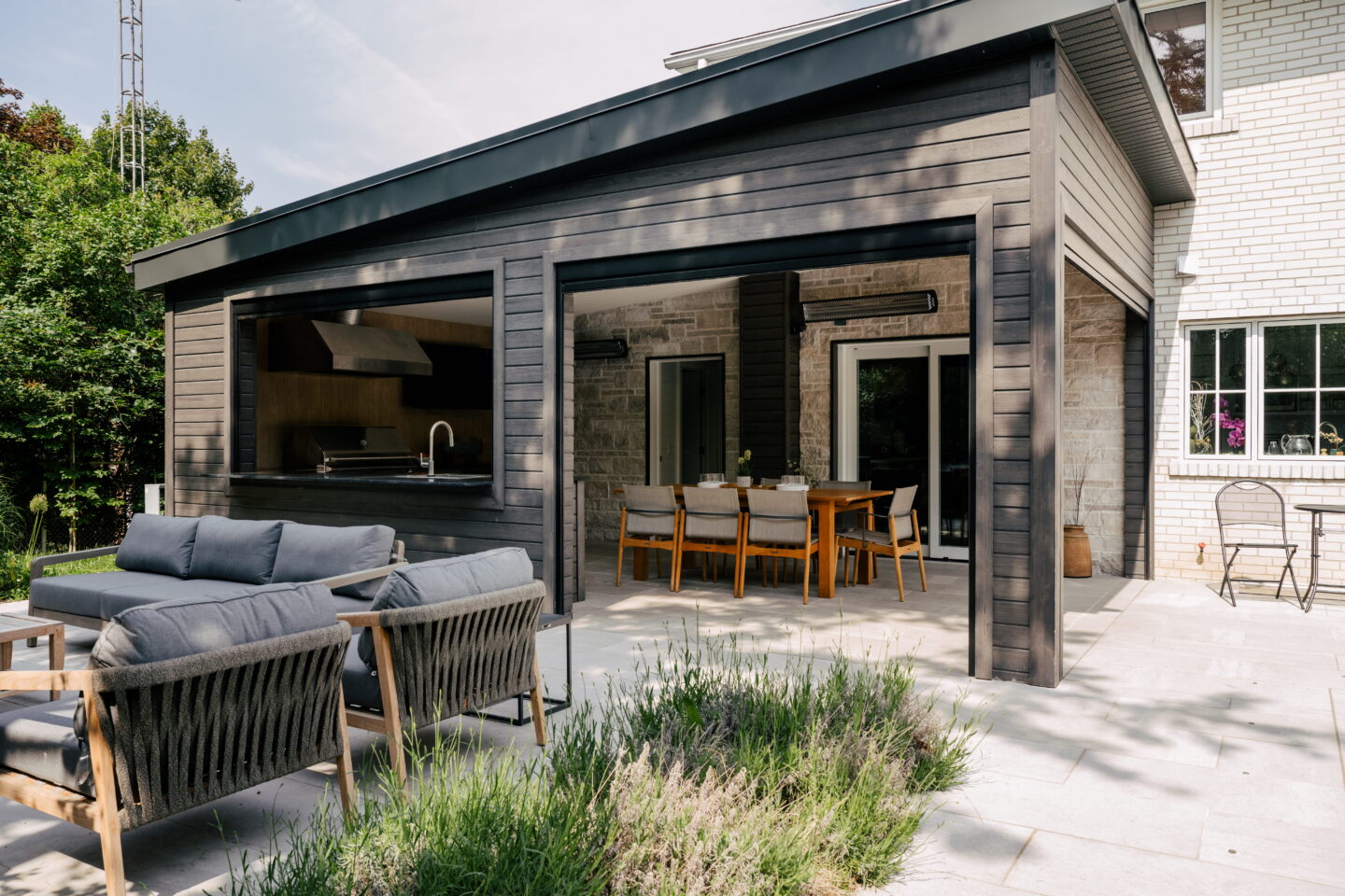 Cabana in the backyard with dining and sitting area beside the pool.