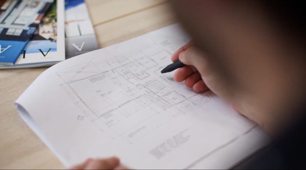 Reviewing architectural floor plans during custom home design process with Alair Homes Red Deer in Central Alberta