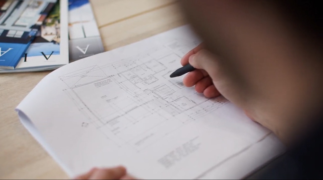 Reviewing architectural floor plans during custom home design process with Alair Homes Red Deer in Central Alberta