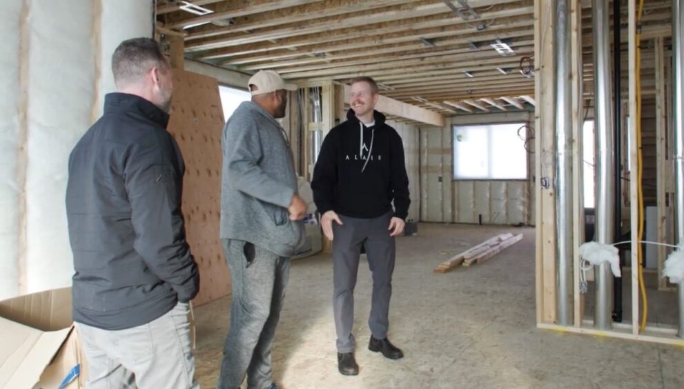 Alair Homes Red Deer team walking through custom home framing stage in Central Alberta during active construction