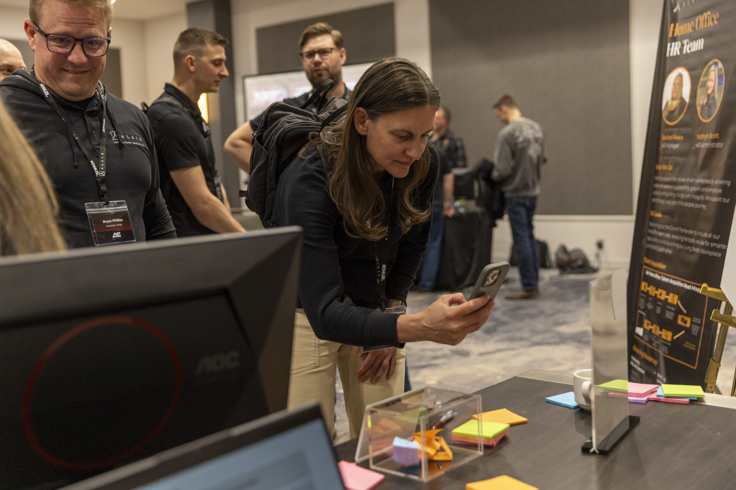 Monica Affleck, regional partner of Alberta, tests a QR code at an Alair Fair booth, where the Alair home office teams shared insights, answered questions, and connected with Alair partners.