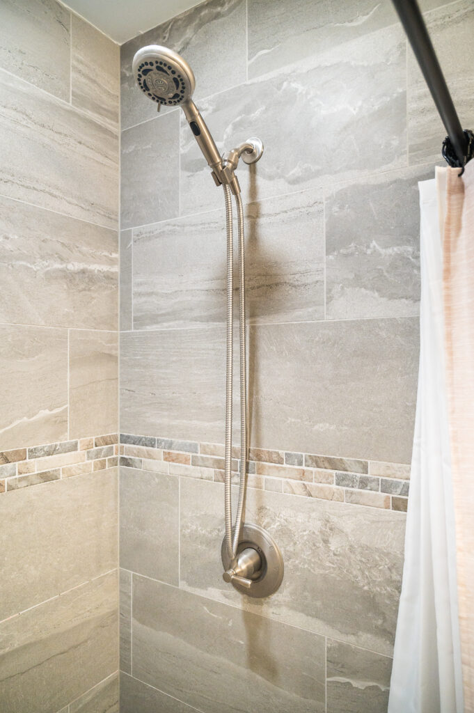Closeup of handheld shower head in the shower.