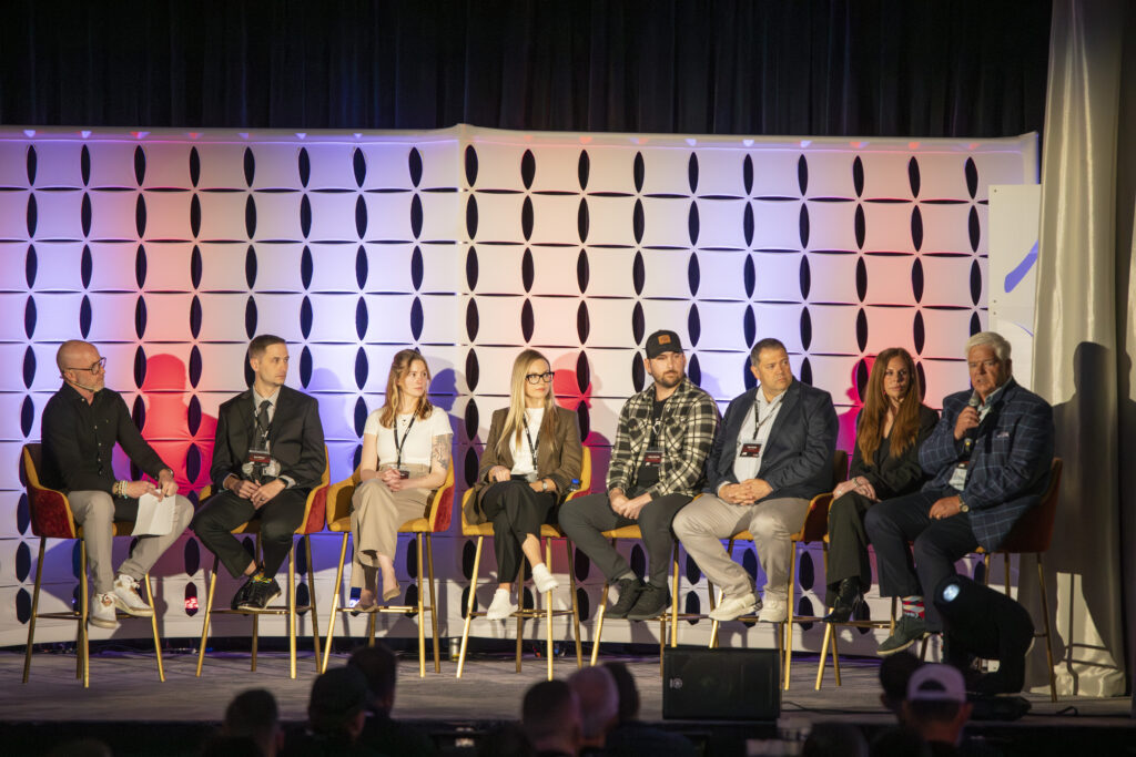 Over a half dozen home appliance and building industry vendor partners sit in chairs onstage during a panel at the 2026 Alair conference.