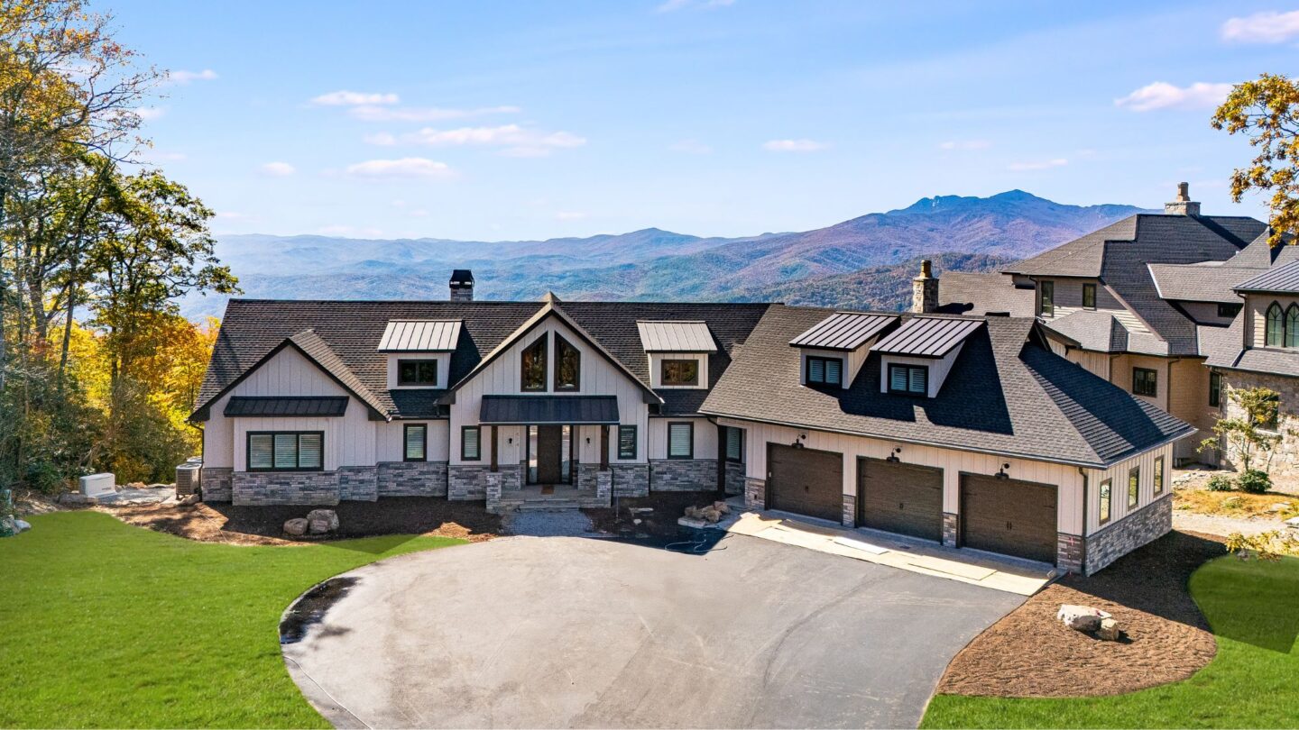 Custom home exterior in Blowing Rock, North Carolina, featuring a mountain ridge setting, expansive driveway, and views of Grandfather Mountain