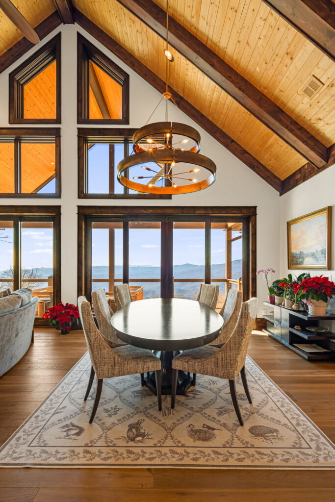 Dining area with mountain views and vaulted wood ceiling.