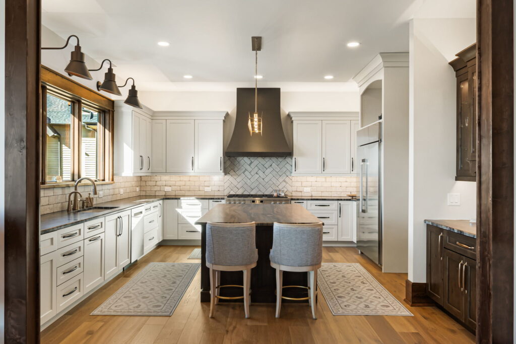 Blowing Rock custom kitchen with large island, white cabinetry, black range hood and herringbone backsplash