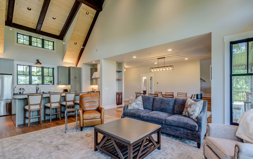 Open-concept living space with vaulted ceilings, custom kitchen, and adjoining dining area.