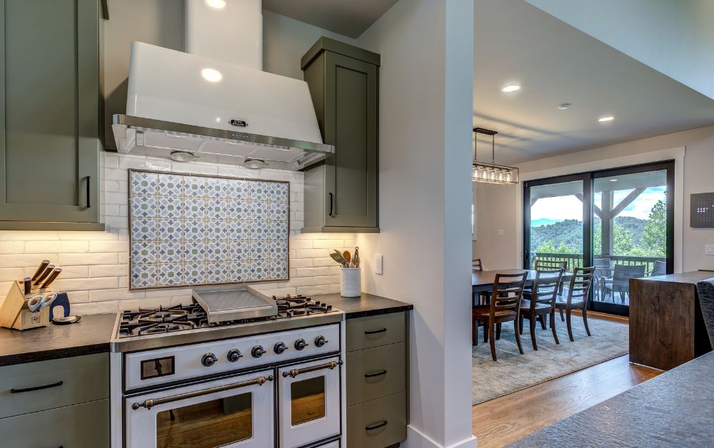 ILVE range with custom tile backsplash and mountain views from the adjoining dining area.