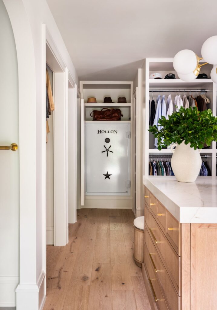 Custom walk-in closet with built-in storage, wood cabinetry, marble-topped island, open shelving, and integrated secure storage.