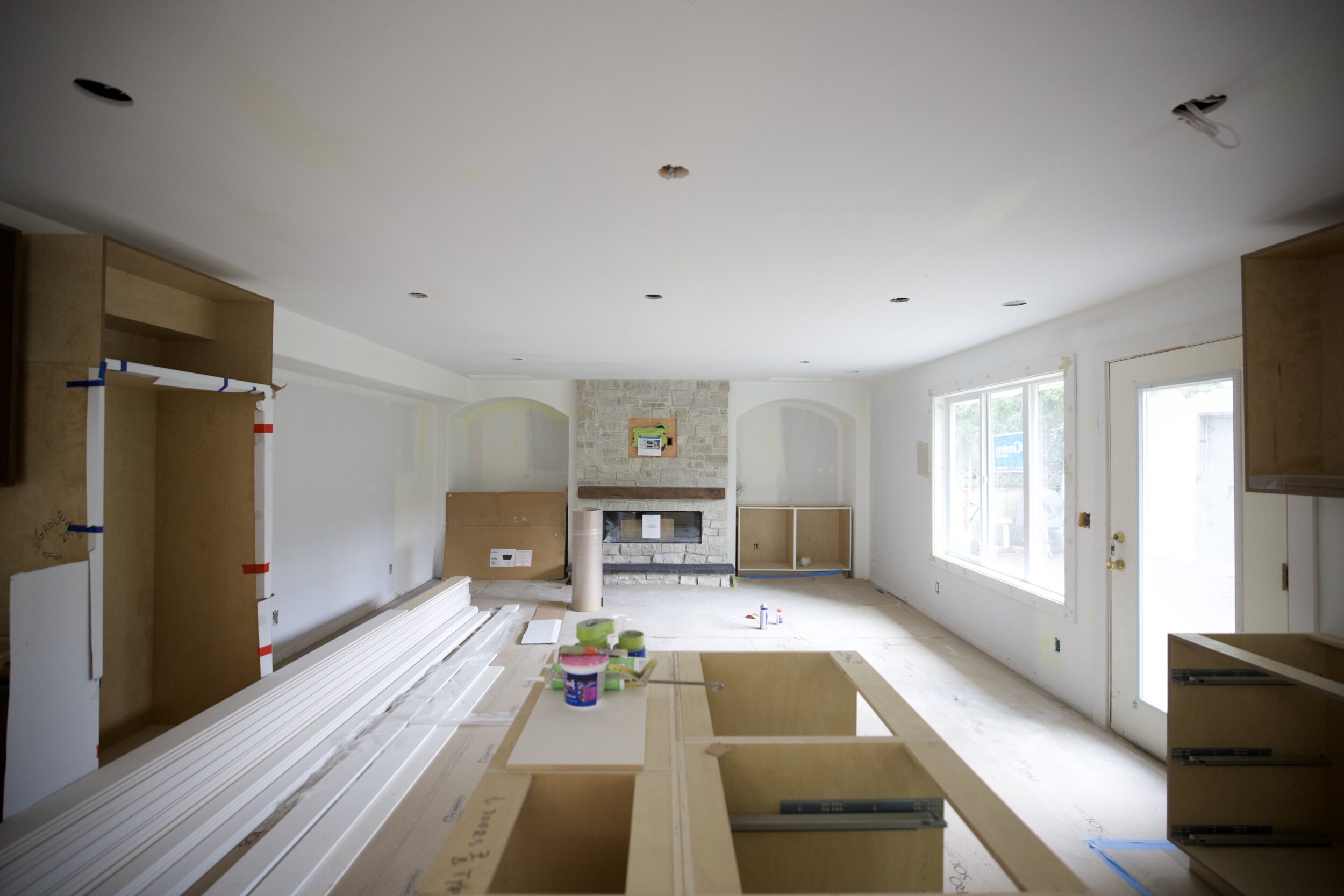 Kitchen renovation in progress in Delta, BC showing plywood cabinet boxes and island framing during installation.